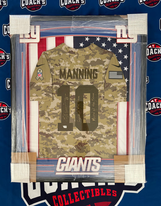 FRAMED Eli Manning Autographed Nike Salute to Service NY Giants Jersey w/ Land of the Free, Home of the Brave Inscription (Fanatics)